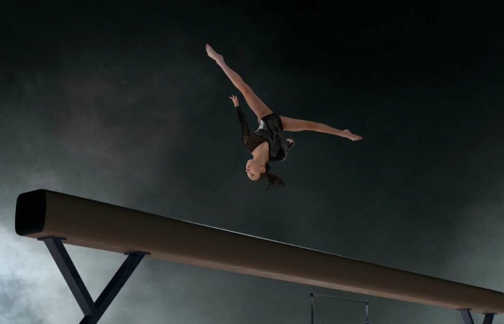 Gymnast performing a flip on a beam